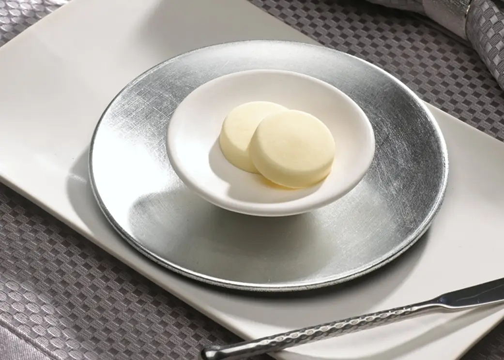 Flavored butter medallions plated with cheese, garlic and lemon