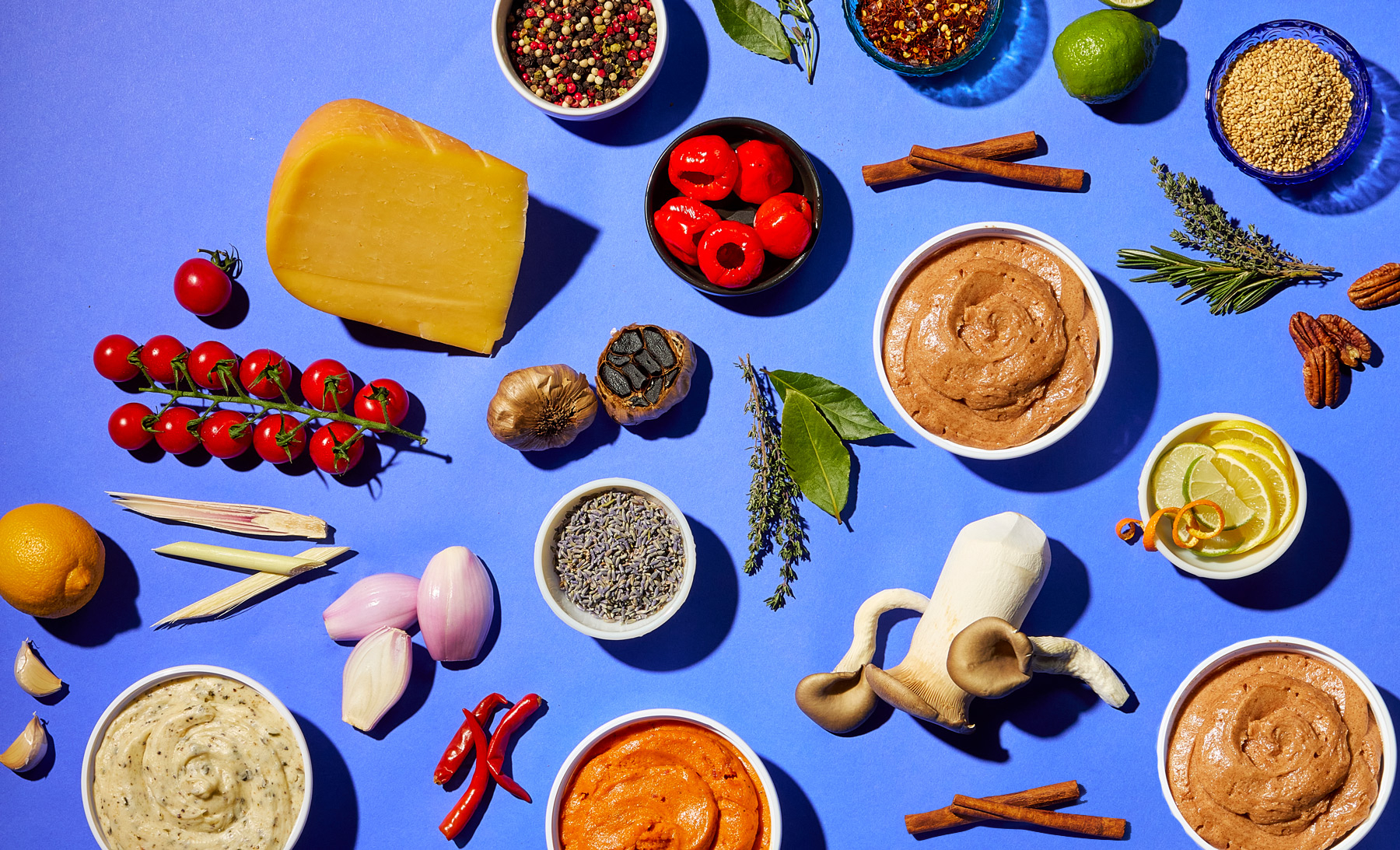 Assortment of compound butter and sauce ingredients on a blue background