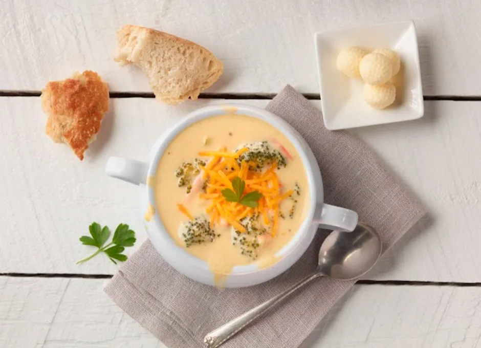 Broccoli cheddar soup with bread slices and butter balls