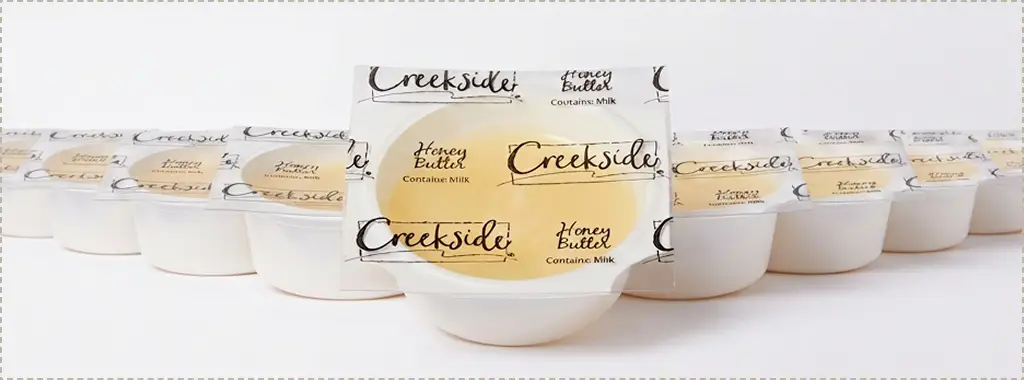 Rows of Creekside Honey Butter cups with one pulled forward