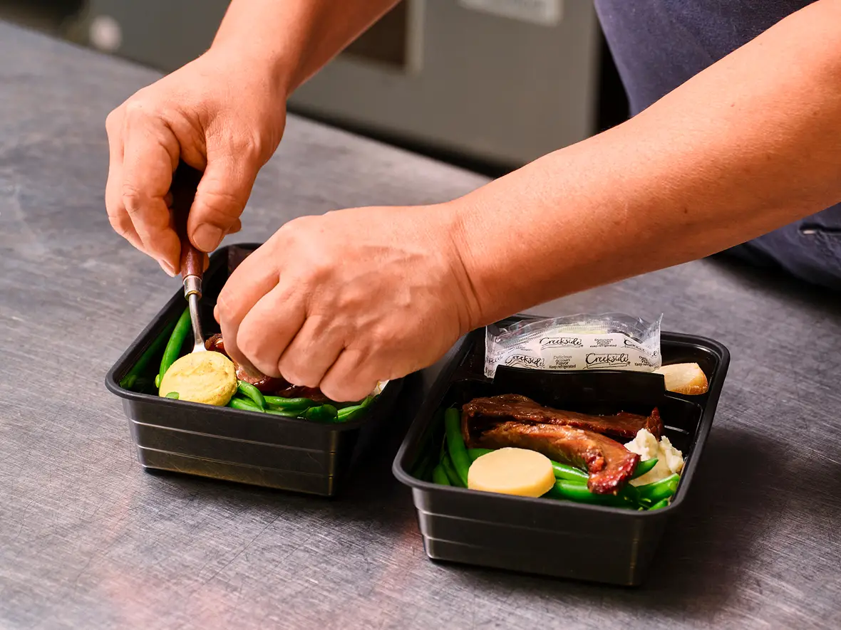 Roasted asparagus topped with dollops of custom flavored compound butter on a tray — kosher and vegan options available