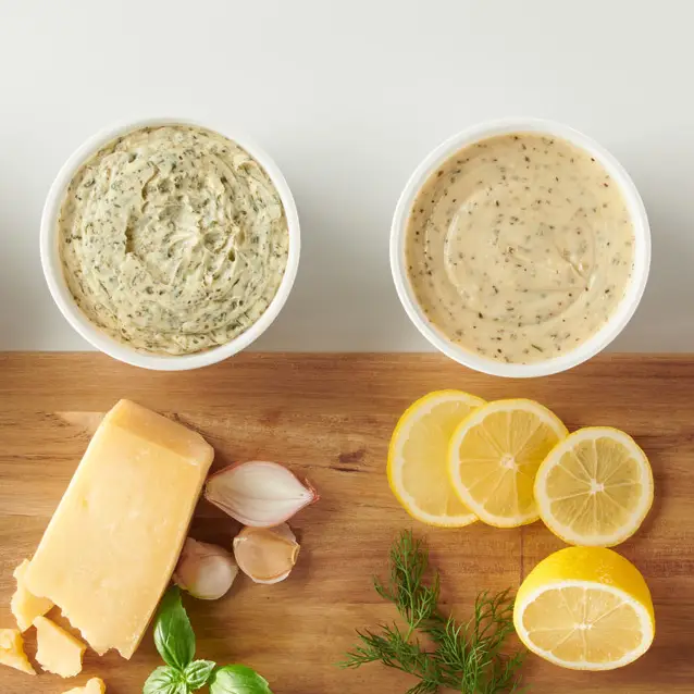Two bowls of whipped herb butter with parmesan, shallots, garlic and lemon