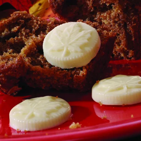 Maple leaf-embossed butter medallions on spiced quick bread