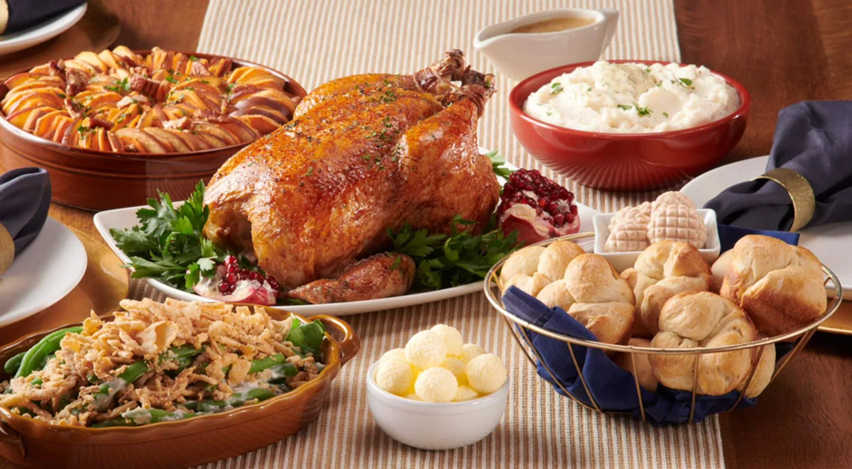 Roast turkey dinner spread with green bean casserole and dinner rolls