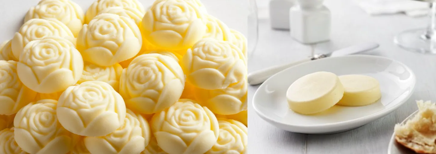 Pile of rose-shaped butter beside a plate of butter pats and bread