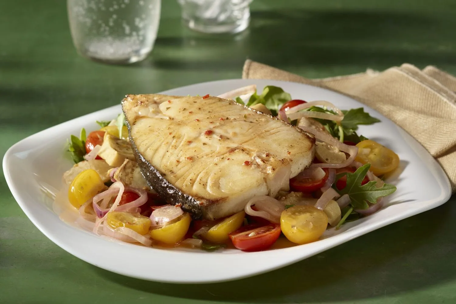 Seared halibut fillet over a cherry tomato and arugula relish