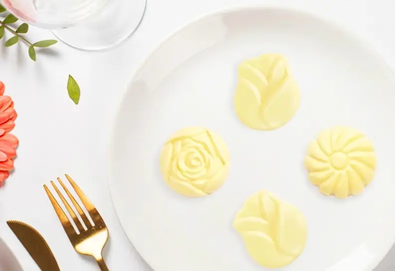 Embossed shaped butter portions on a plate