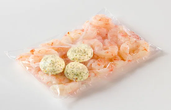 Shrimp in a bag topped with three round butter dollops