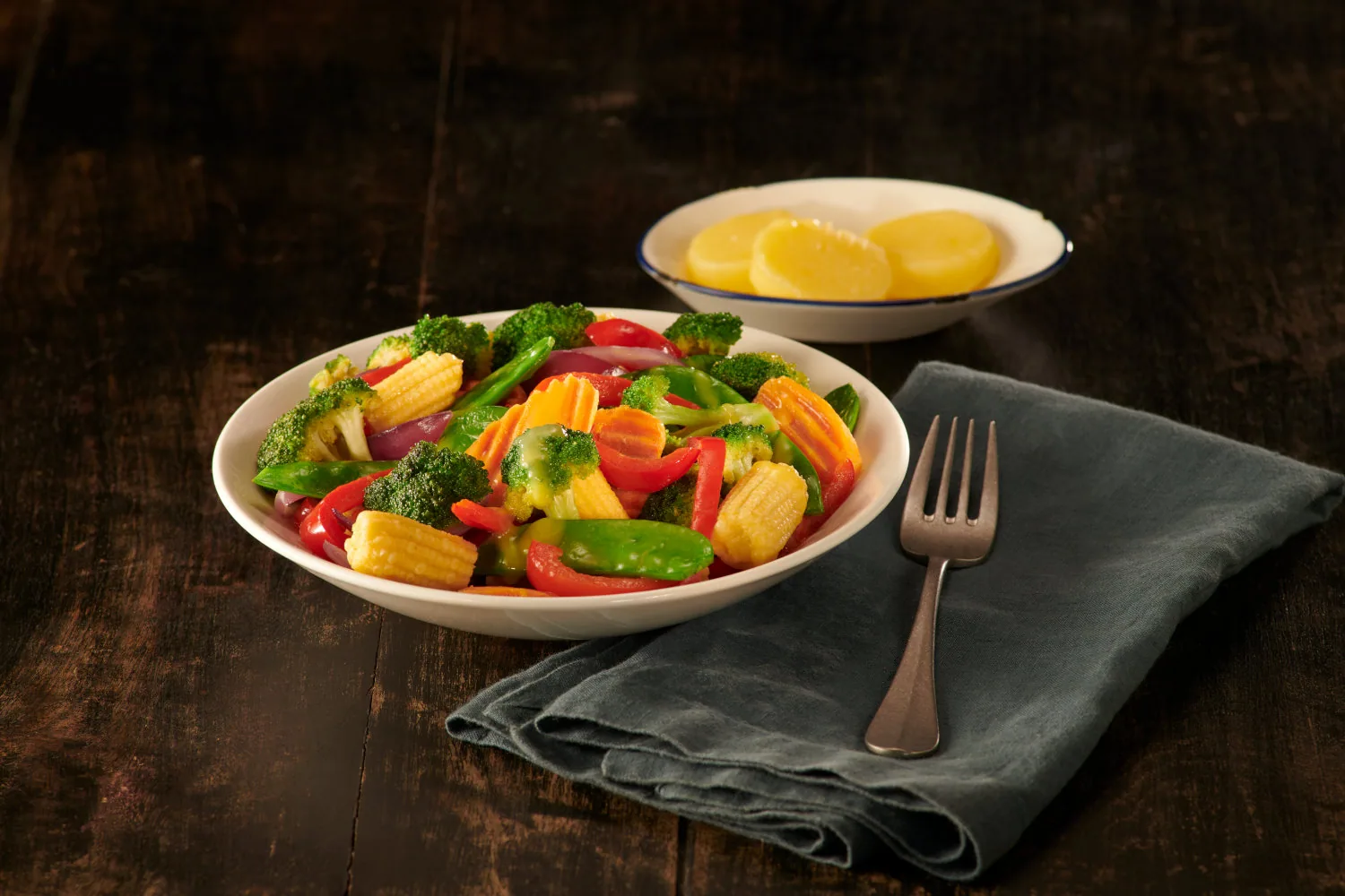 Bowl of stir-fried vegetables beside a small bowl of pineapple slices