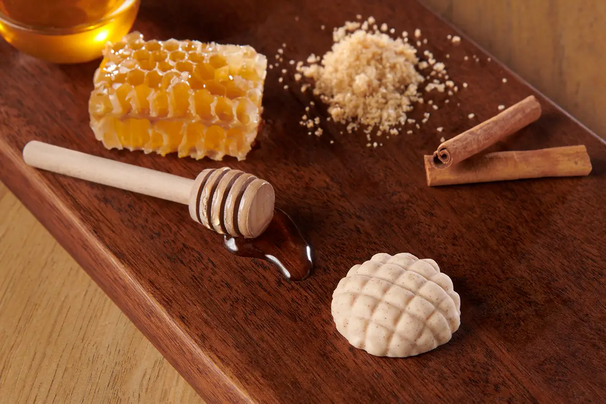 Dozens of ready-to-go flavors — molded butter balls and roses in dishes beside sliced baguette on a wooden board
