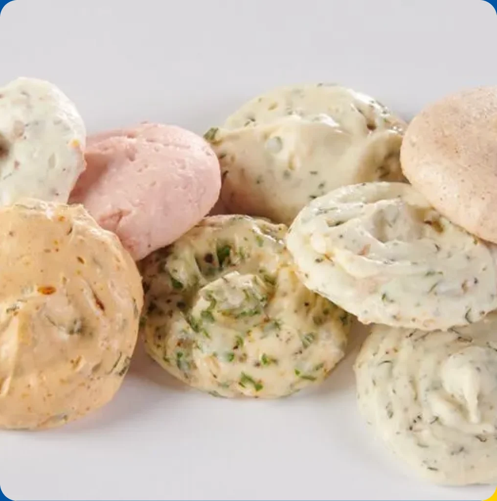 A pile of assorted flavored butter dollops in herb, citrus and berry varieties