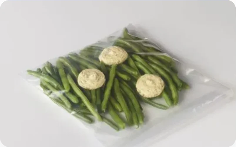 Green beans in a steam bag with three flavored butter dollops